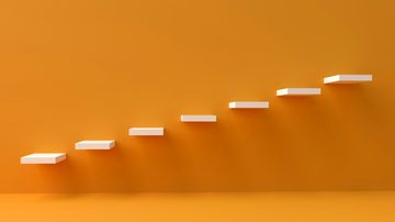 Illustration of ascending white steps against an orange background.